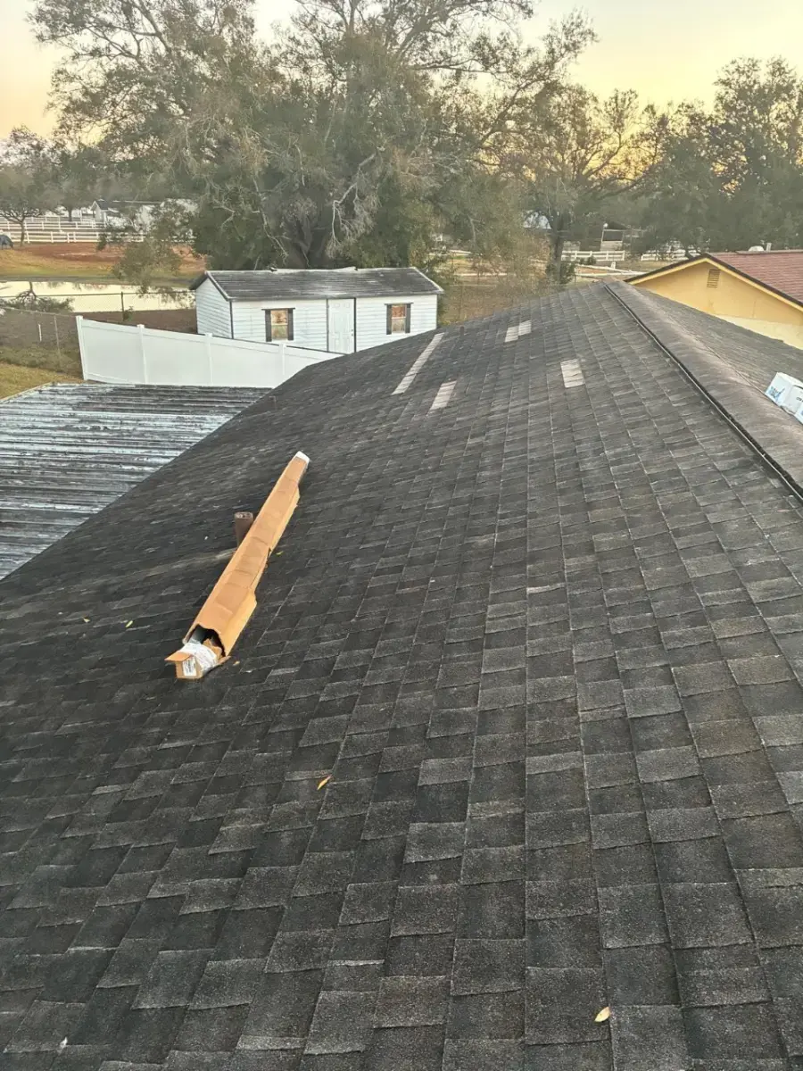 Contact Us Today Roofing materials laid out on a shingled residential roof during a roof repair in a suburban neighborhood